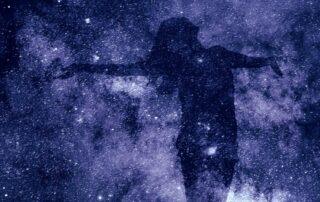 Individual with arms stretched wide with a celestial background.